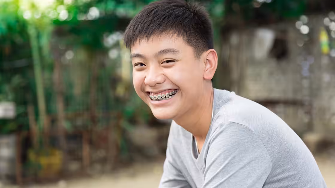 Boy Smiling With Braces During Orthodontic Treatment